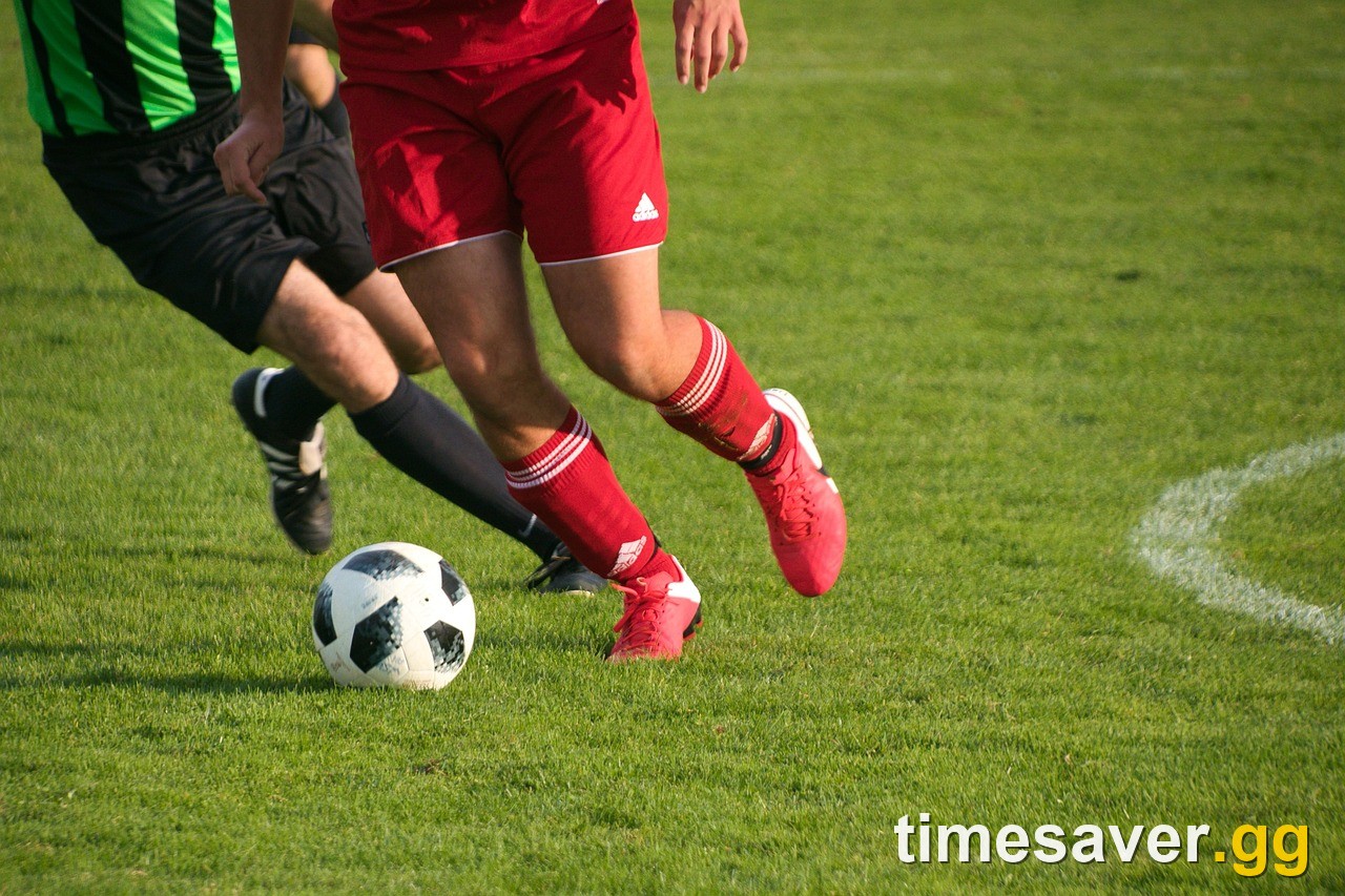 Soccer player controlling the ball during a competitive match under stadium lights