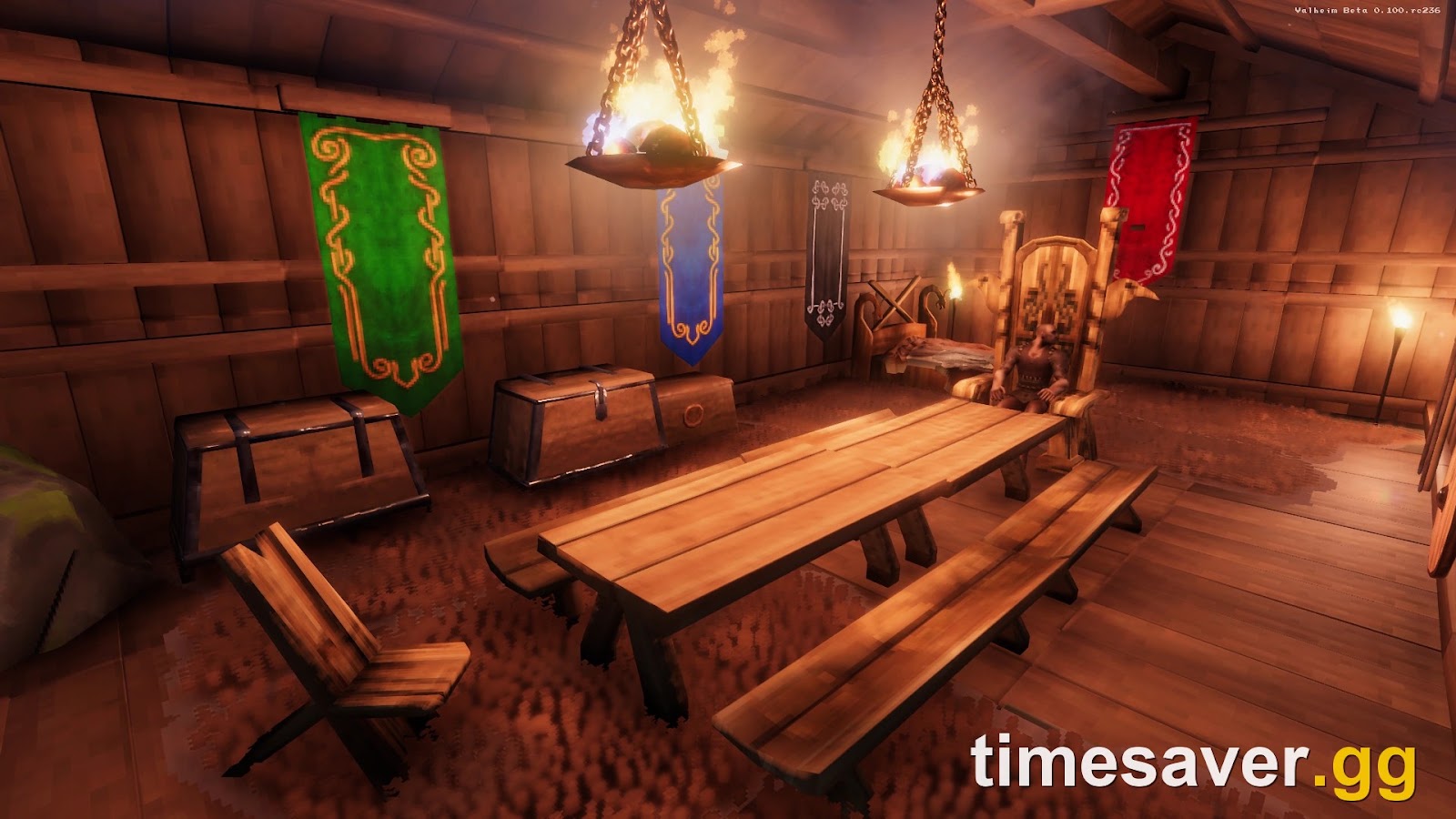 A comfy Valheim interior with a long table, chairs, banners, chests and lit braziers that raise the comfort level for the Rested buff