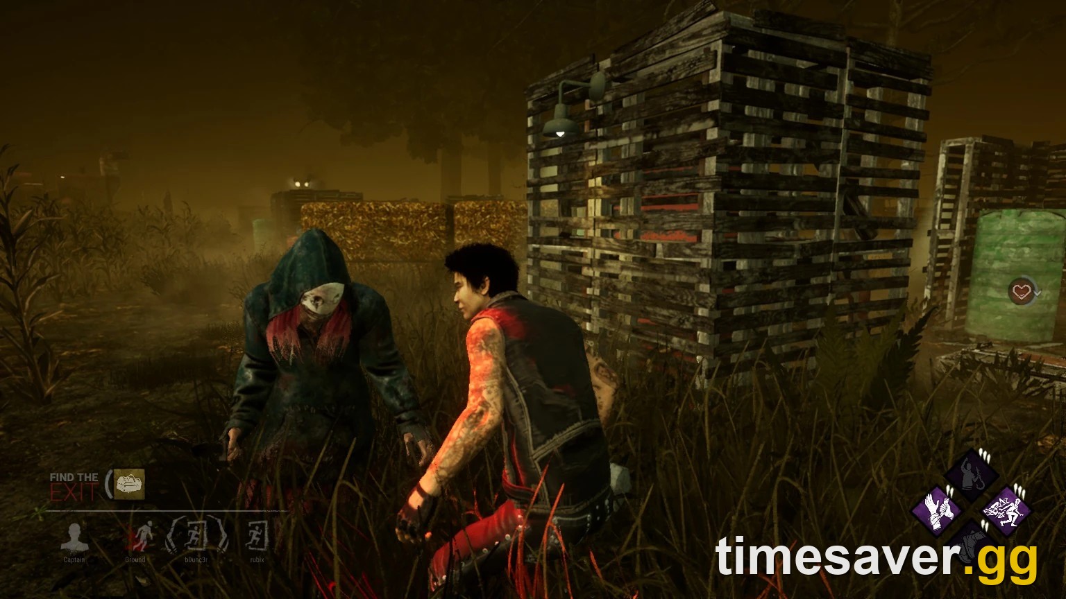 In-game Dead by Daylight screenshot of The Legion in a hooded jacket and smiling mask closing on an injured survivor beside a pallet on the Ormond map